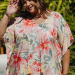 Close-up on plus-size model wearing Springtime Kaftan showing v-neckline with hand-coloured tassels and pink floral print details