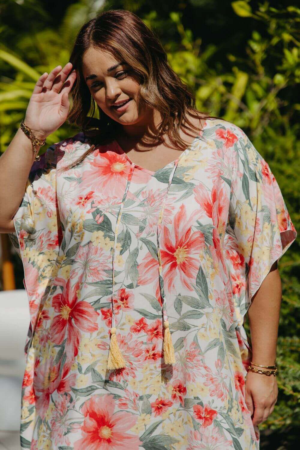 Close-up on plus-size model wearing Springtime Kaftan showing v-neckline with hand-coloured tassels and pink floral print details