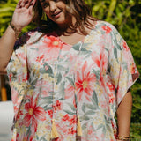Close-up on plus-size model wearing Springtime Kaftan showing v-neckline with hand-coloured tassels and pink floral print details