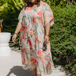Plus-size model walking poolside in white Springtime Kaftan with bold pink and crimson floral print – breezy summer resort style