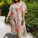 Plus-size model walking poolside in white Springtime Kaftan with bold pink and crimson floral print – breezy summer resort style