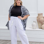 Zebra print kimono cape styled with white cotton pants and black t-shirt for relaxed resort layering