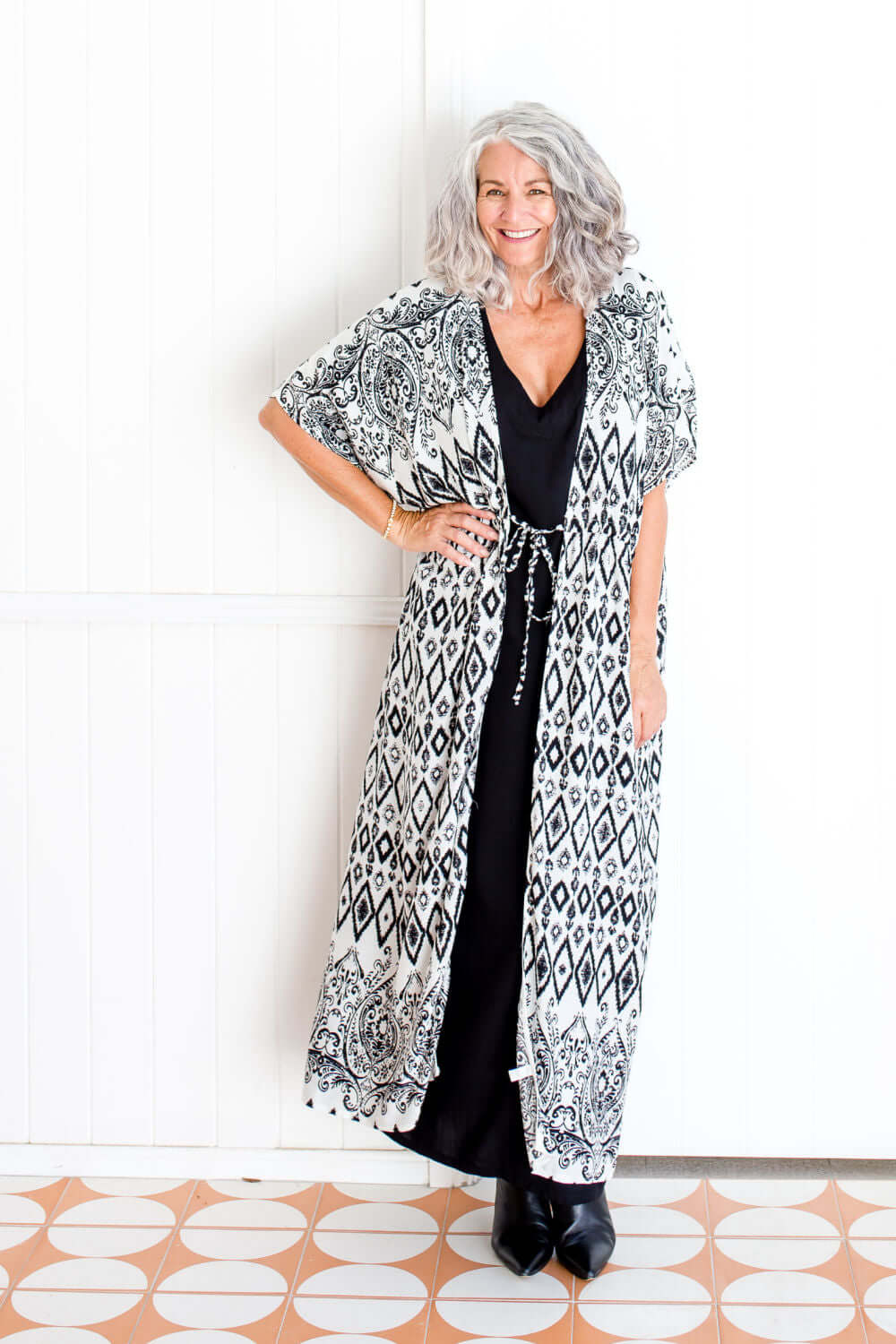 Geo print maxi kimono jacket styled over black maxi kaftan dress on size 8–10 model
