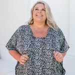 Close-up of rayon leopard print fabric in black, grey and white showing texture and pattern details