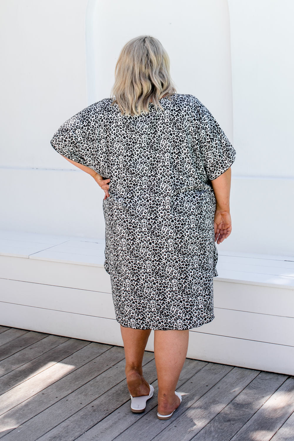 Back view of plus size model in 2XL leopard print kaftan showing relaxed fit and drape.